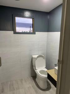a bathroom with a toilet and a window at Alor Lanchang Roomstay in Arau +5 photos