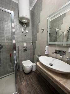 a bathroom with a sink and a toilet and a mirror at Silveroks Apartment in Prilimanskoye