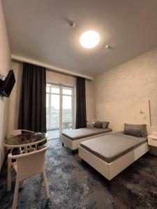 PrilimanskoyeにあるSilveroks Apartmentのベッド2台とテーブルが備わるホテルルームです。