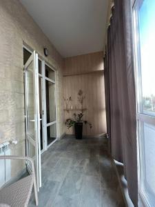 un pasillo con una gran puerta de cristal y una planta en Silveroks Apartment, en Prilimanskoye