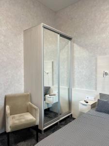 a bedroom with a glass cabinet with a sink and a chair at Silveroks Apartment in Prilimanskoye +133 photos