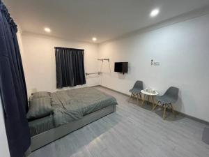 Schlafzimmer mit einem Bett, einem Tisch und Stühlen in der Unterkunft Alor Lanchang Roomstay in Arau