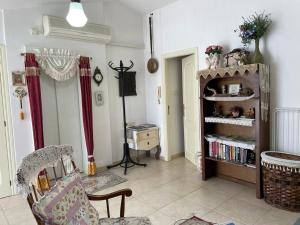 uma sala de estar com uma cadeira e uma estante de livros em Shelly's Home Boutique Apartments em Ramat Gan