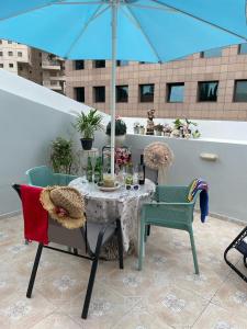 a table and chairs with an umbrella on a patio at Shelly's Home Boutique Apartments in Ramat Gan