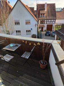 un balcone con 2 sedie, un tavolo e una pianta di Apartment Hofheimer Altstadt a Hofheim am Taunus