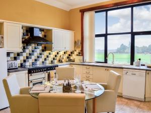 a kitchen with a table and chairs and a kitchen with a window at Redroofs By The Woods - Uk41559 in Letham