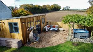 a backyard with a tiny house and a hot tub at Cotswold Way Getaway Home & Cabin Sleeps 20 in Chippenham