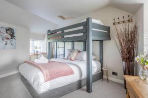a bedroom with a bunk bed with white sheets at Cotswold Way Getaway Home & Cabin Sleeps 20 in Chippenham