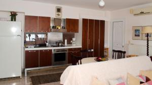 a kitchen and dining room with a table and a refrigerator at Atena Mare Sea View in Perama +24 photos