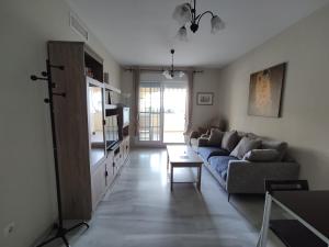 ein Wohnzimmer mit einem Sofa und einem Tisch in der Unterkunft Flamingo Sol Home in Torremolinos