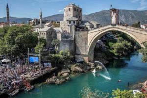 a bridge over a river with a crowd of people at Apartment Sun - 70m2 comfortable apartment in Mostar
