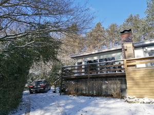 a car parked next to a house in the snow at Au repos de Zoé in Waulsort