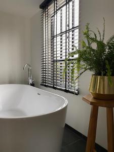 a white bath tub in a bathroom with a window at B&B Het goudklompje 
