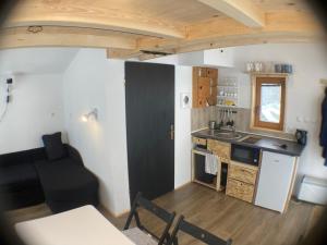 une petite cuisine avec une porte noire et une chaise noire dans l'établissement Tiny house, à Mislinja