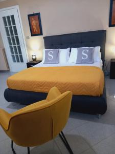 - une chambre avec un grand lit et une chaise jaune dans l'établissement Sun Suite Sorrento center, à Sorrente