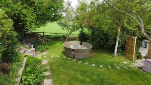 a garden with a large tub in the grass at Log Cabin near Bath in Chippenham