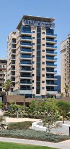ein großes Apartmenthaus inmitten eines Parks in der Unterkunft Tulip Creek Hotel Apartments in Dubai