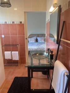 baño con mesa de cristal y cama en Plage & Repos - Hermitage les bains, en La Saline-Les-Bains