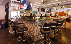 a bar with black bar stools in a restaurant at Traveller's Rest Sports Bar in Pattaya