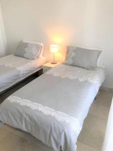 two twin beds in a room with a lamp at Beautiful 2 Bed Apartment on Villamartin Plaza in Villacosta