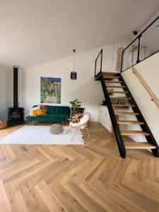 a living room with a staircase and a couch at B&B Het goudklompje in Hengelo