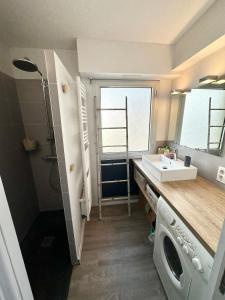 een badkamer met een wastafel en een wasmachine bij EXCEPTIONNEL ! T3 Duplex – Vue mer 180° sur le port de Lomener in Ploemeur