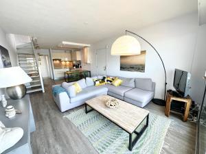 een woonkamer met een bank en een tafel bij EXCEPTIONNEL ! T3 Duplex – Vue mer 180° sur le port de Lomener in Ploemeur