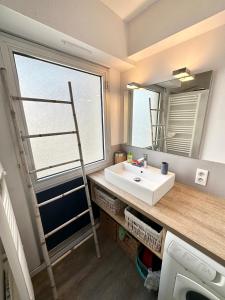 een badkamer met een wastafel en een spiegel bij EXCEPTIONNEL ! T3 Duplex – Vue mer 180° sur le port de Lomener in Ploemeur
