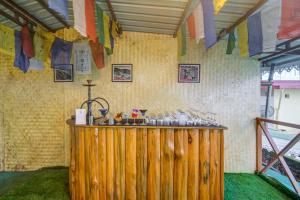 drewniany bar w pokoju z flagami na ścianie w obiekcie Summit Namnang Courtyard & Spa w mieście Gangtok