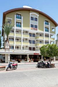 two motorcycles parked in front of a large building at HOTEL MİTOS in Alanya