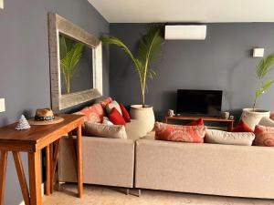 ein Wohnzimmer mit einem Sofa und zwei Topfpflanzen in der Unterkunft Kin Tulum - Puerta Azul Luxury in Tulum