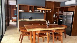 eine Küche mit einem Holztisch und einem Kühlschrank in der Unterkunft Kin Tulum - Puerta Azul Luxury in Tulum
