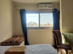 a room with a window with a chair and a bed at Seror Guest House in Cairo