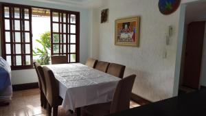 uma sala de jantar com uma mesa branca e cadeiras em Diversão, churrasco e piscina - Praia de Ipitanga em Salvador