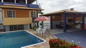 a villa with a swimming pool and a house at Diversão, churrasco e piscina - Praia de Ipitanga in Salvador