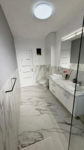 a white bathroom with a sink and a toilet at Magic Mirror in Satu Mare