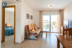 Sala de estar con silla y dormitorio en Apartamentos Bovalar Casa Azahar, en Alcossebre