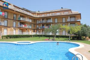 a hotel with a large swimming pool in front of a building at Apartamentos Bovalar Casa Azahar in Alcossebre