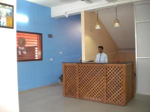 a man sitting at a desk in a room at Rains Inn Eco Hotel in Diphu