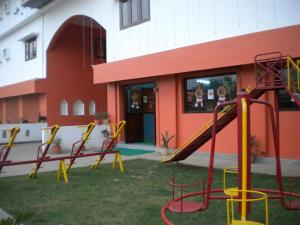 a playground with a slide in front of a building at Rains Inn Eco Hotel in Diphu