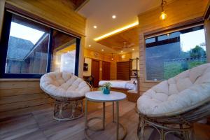 a room with two chairs and a table in a house at Vrindhavan Farm Suites in Kanthalloor
