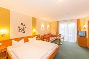 um quarto de hotel com uma cama grande e uma televisão em Villa Osada em Binz