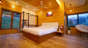 a bedroom with a bed and a chair in it at Vrindhavan Farm Suites in Kanthalloor