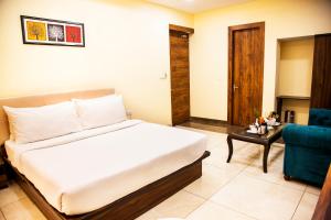 a hotel room with a bed and a blue chair at Clarks Inn Dudhwa in Paliā Kalān