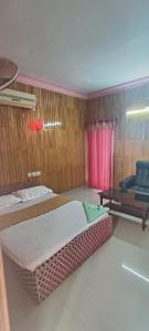 Hotel Greenvalley Residency في Punalūr: غرفه سريرين وكرسي فيها