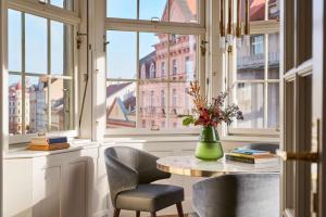 um quarto com uma mesa com cadeiras e um vaso com flores em Andaz Prague - a Concept by Hyatt em Praga