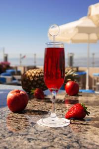a glass of red wine sitting on a table with strawberries at Baity Boutique Hotel in Aqaba