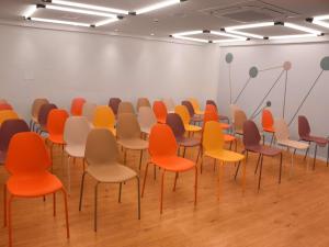 een kamer met rijen stoelen met oranje bij Ibis Styles Garanhuns in Garanhuns