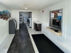 a room with a hallway with refrigerators and a television at Motel 6 Hagerstown MD in Hagerstown