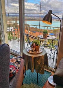 a room with a table and a balcony with a view at Villa Borostyán in Tihany
